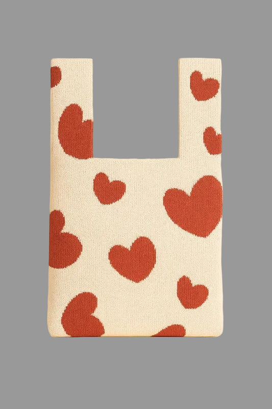 knitted bag with red heart pattern on a grey  background