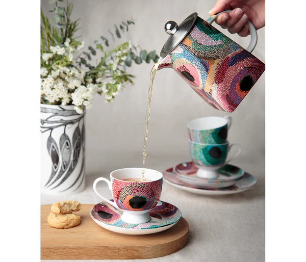 A lifestyle picture depicting a teapot pouring tea into a teacup and saucer by  Aboriginal Australian artist, Marianne Burton.