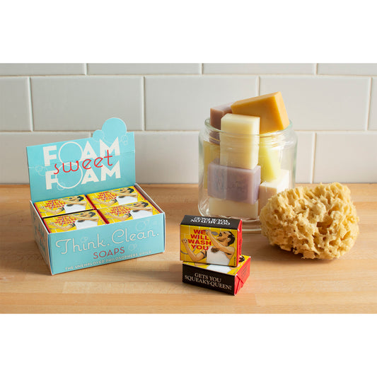 A bathroom countertop featuring a jar of soaps, a sea sponge and a cdu of packaged soaps "We will wash you soap-Freddie Mercury" by The Unemployed Philosophers 