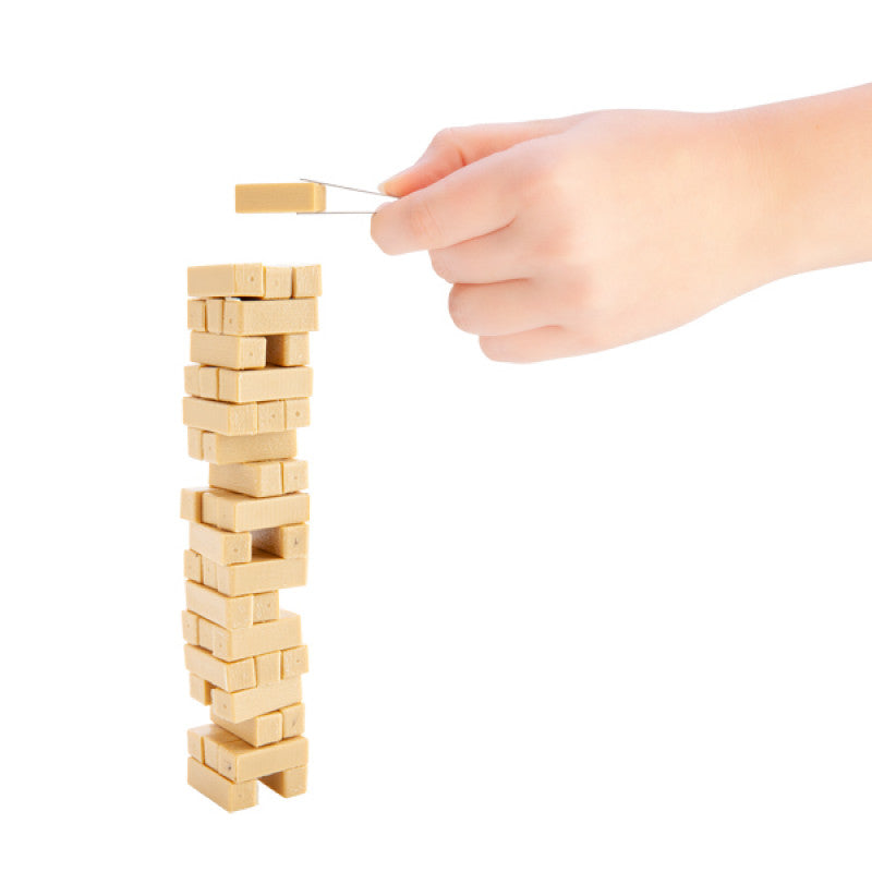 Hand placing a wooden block on a tower of blocks against a white background