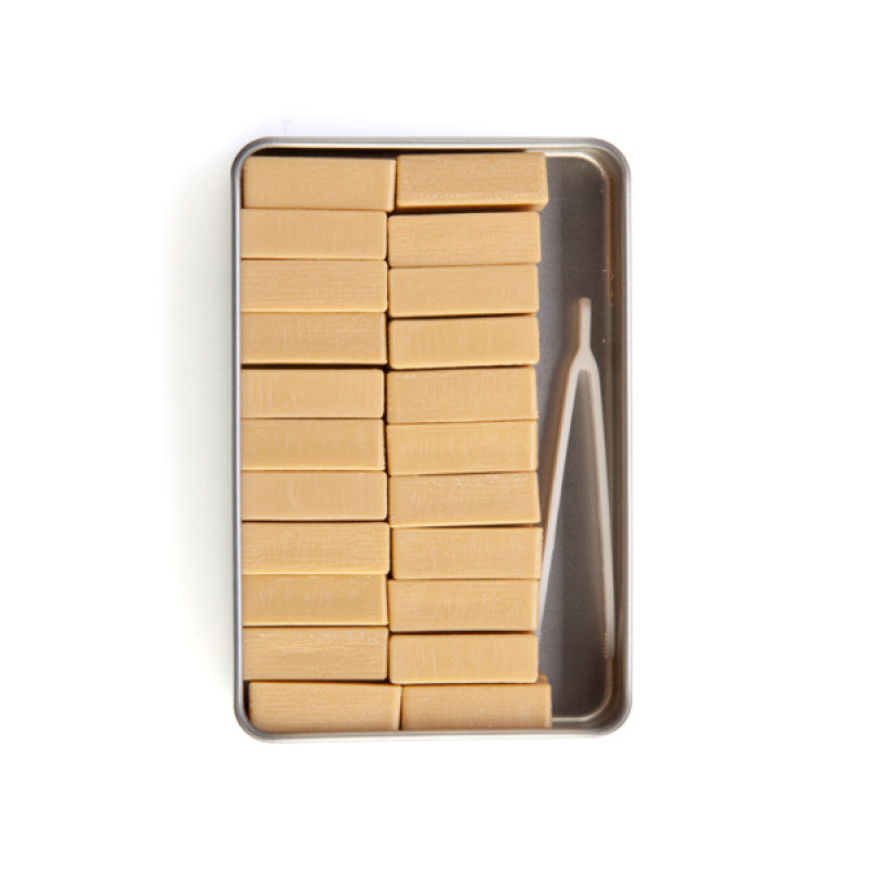 Set of wooden blocks in a metal tin with a tweezers on a white background