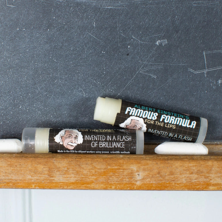 Two lip balm tubes with Albert Einstein's face on a chalkboard background