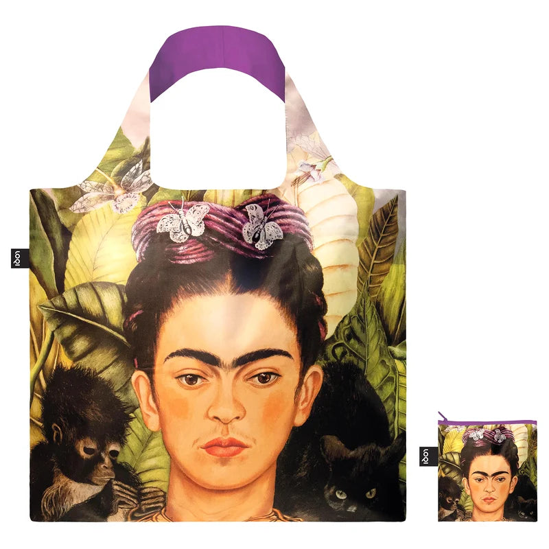 A shopping tote featuring Frida Kahlo artist and a smaller pouch with the same print to its right lower corner. The background is white.