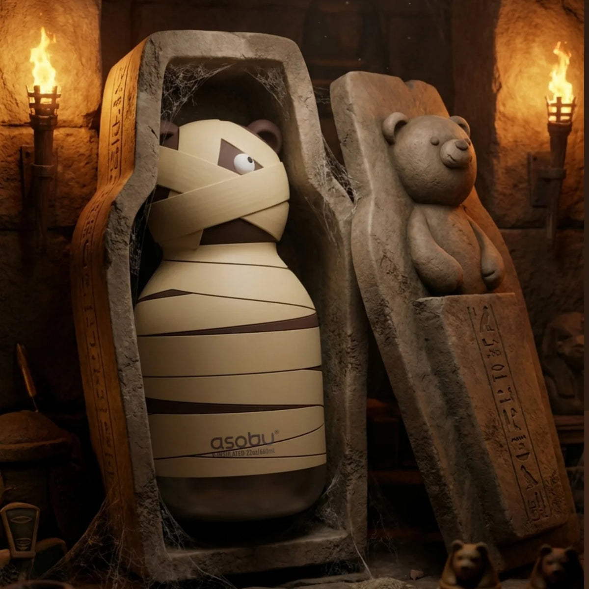 A brown bear Spookies drink bottle in a crypt setting and placed in an open stne setting.The lid is askew and has a raised bear and hieroglyphics