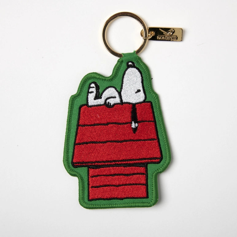Keychain with cartoon design of a doghouse and two dogs on a white background