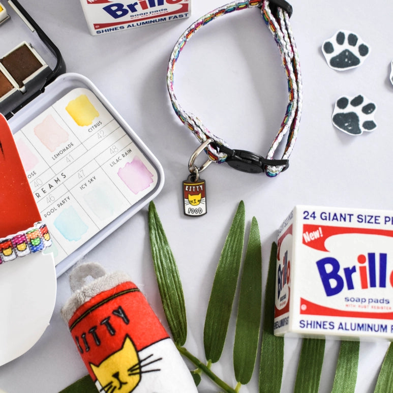 Cat-themed products including a collar, pouch, and soap pads on a white background with green leaves.