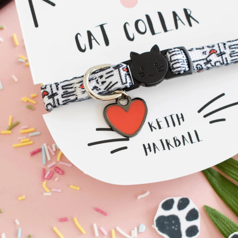 Cat collar with a heart-shaped tag on a pink background with cat-themed elements.