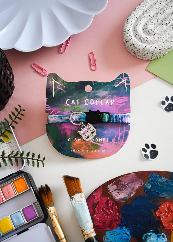 Cat collar with colorful design on a pink surface with art supplies