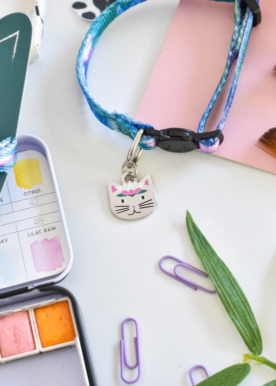 Cat collar  with a cat-shaped charm on a desk with stationery items