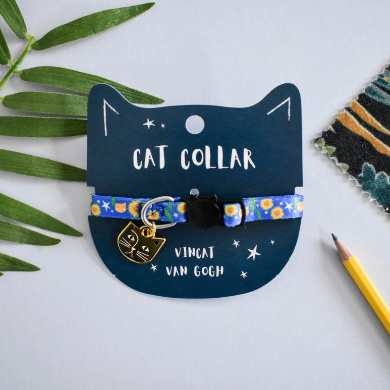 Cat collar with Van Gogh design on a blue card with cat illustration, surrounded by green leaves and a pencil.