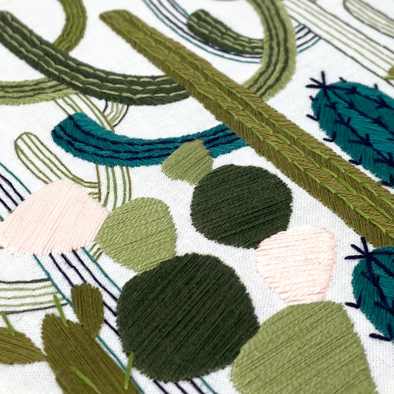 closeup needlework of the Cactus garden threadwork in various colours of green.
