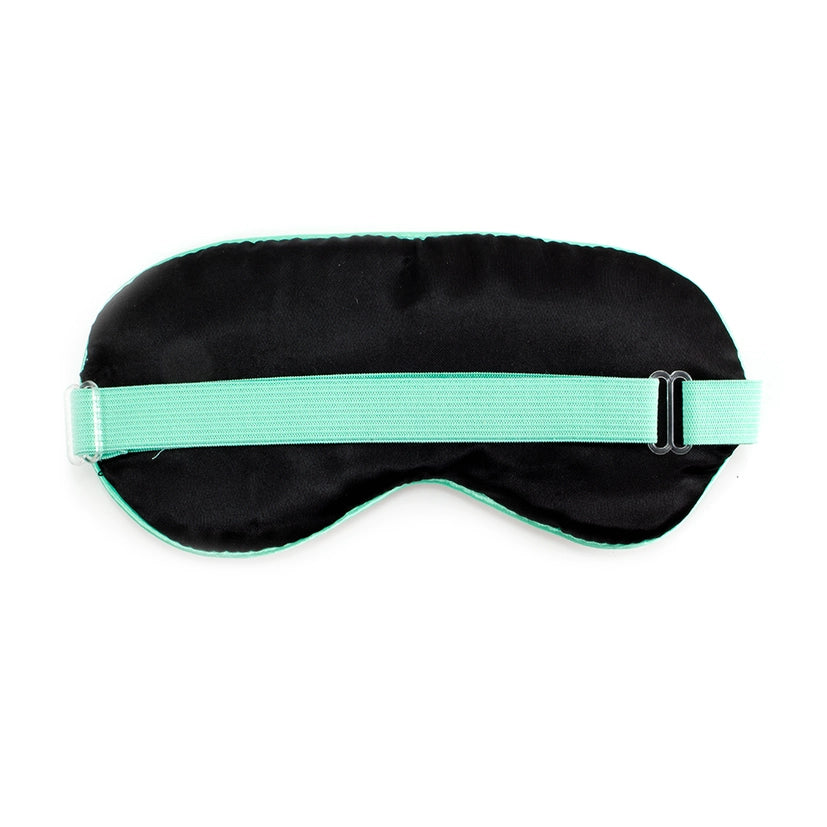 A back view of a  black sleep mask with a green strap on a white background.