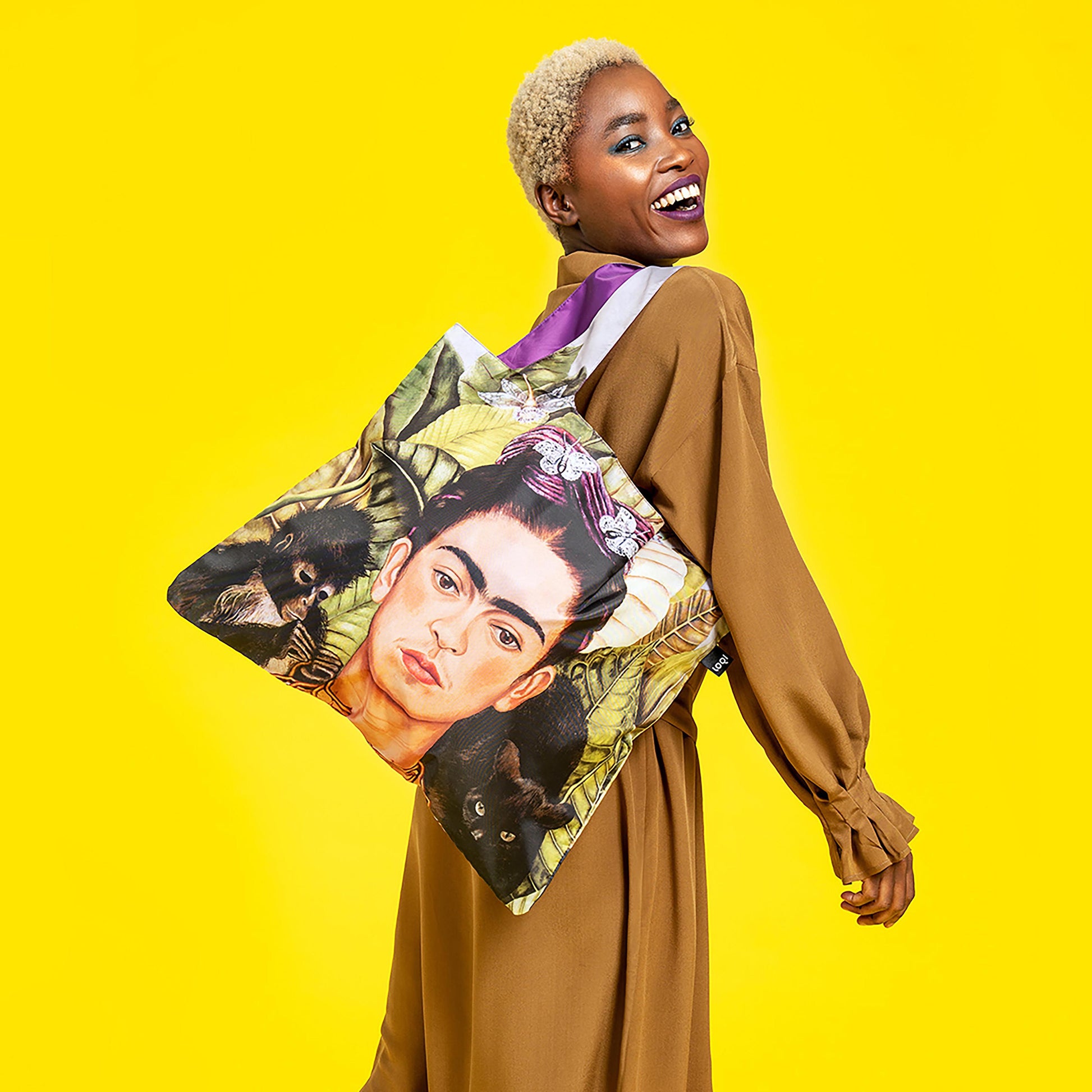 Woman carrying a bag with a colorful design on a yellow background