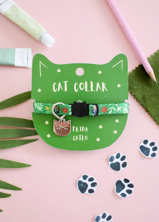 Cat collar with decorative elements on a green card, surrounded by green leaves and paw prints on a pink background.