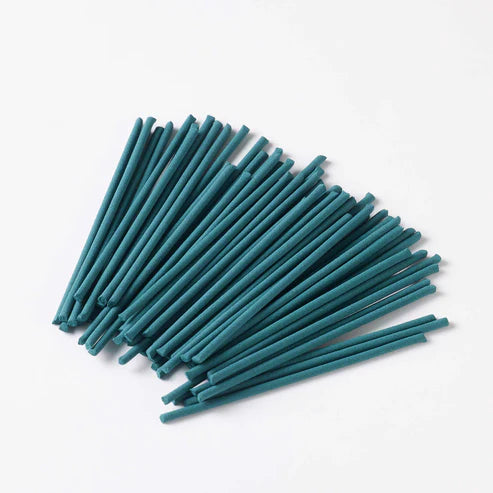 Teal incense sticks arranged in a fan-like pattern on a white background