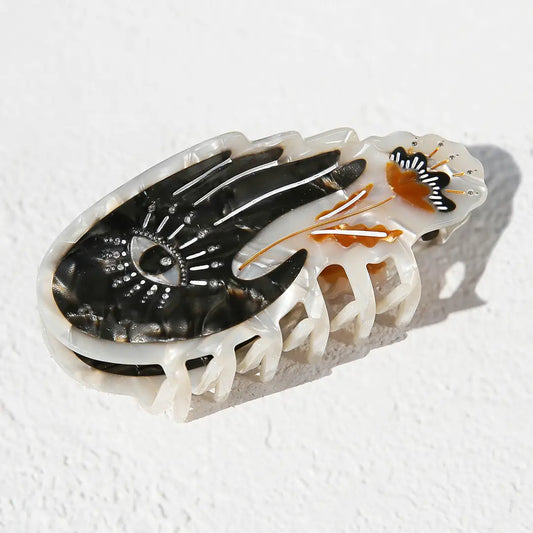 Decorative hair clip with black and white design on a white background