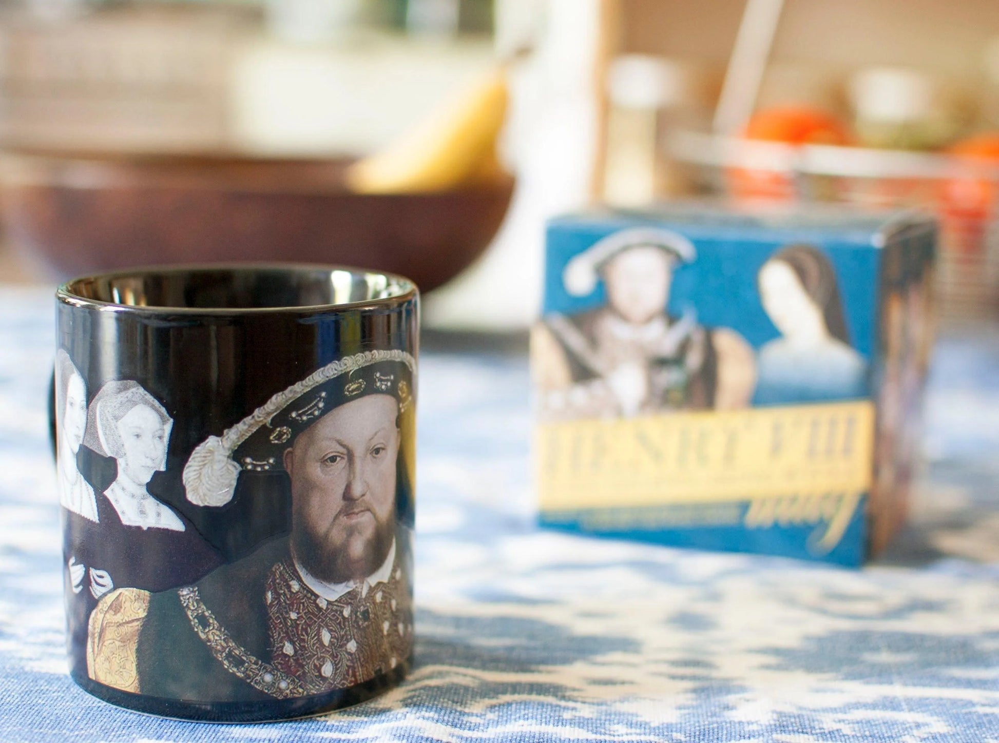 Black mug with historical design on a table with a blurred background