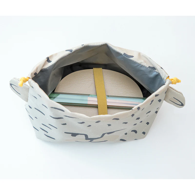Hexagonal pouch with a patterned interior, containing notebooks on a white background