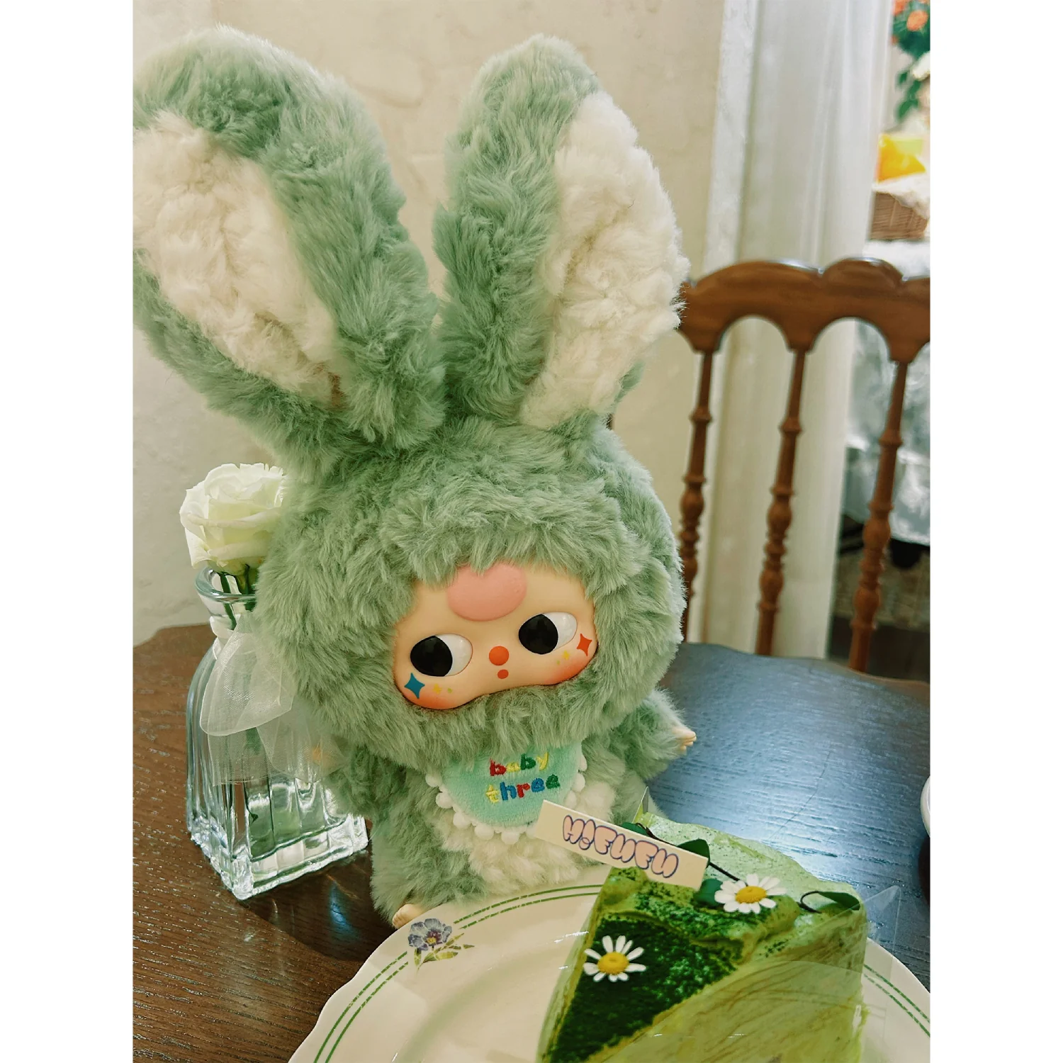 Green plush toy with bunny ears on a table