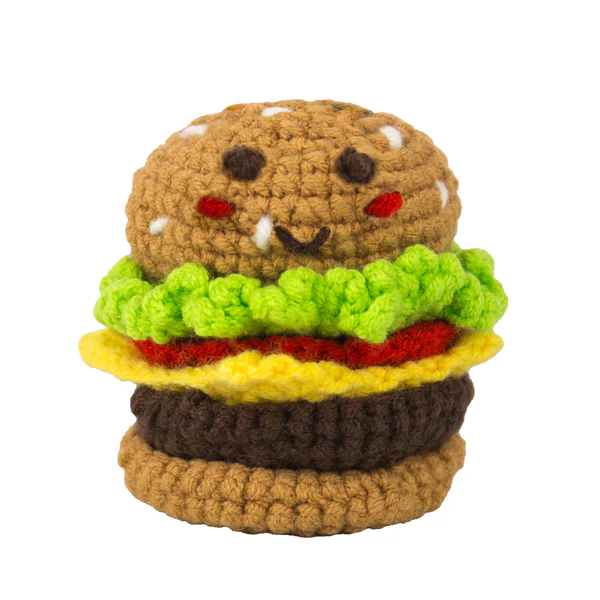 Crocheted toy hamburger with face on a white background