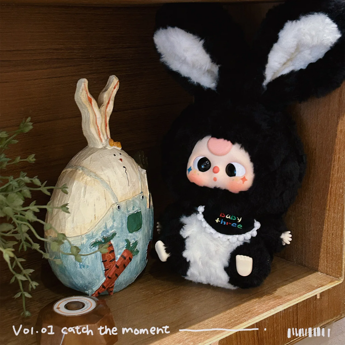 Plush toy with bunny ears and a decorative egg on a wooden shelf.