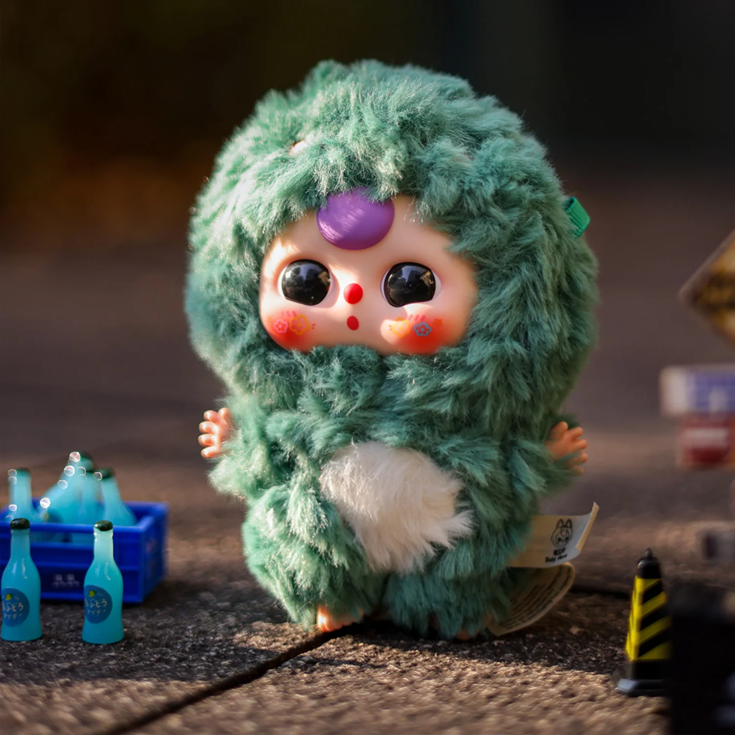 Plush toy resembling a character with green fur and purple eyes on a dark background