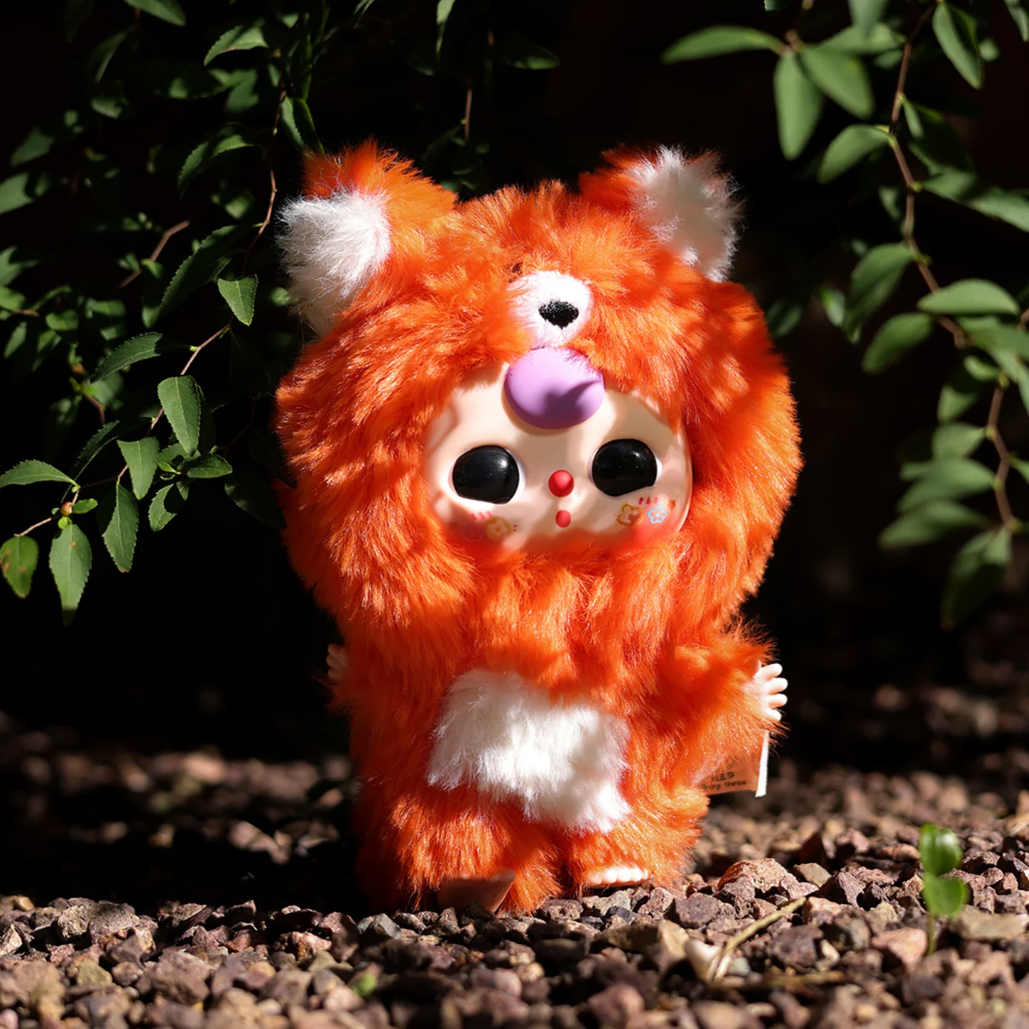 Plush toy resembling a red panda on a natural background