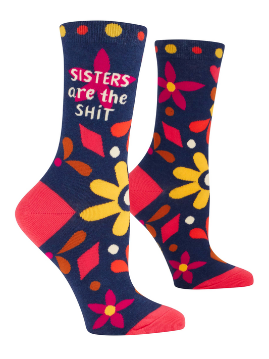 Side profile blue women's crew socks with floral design and text that reads:"Sisters are the shit" on a white background