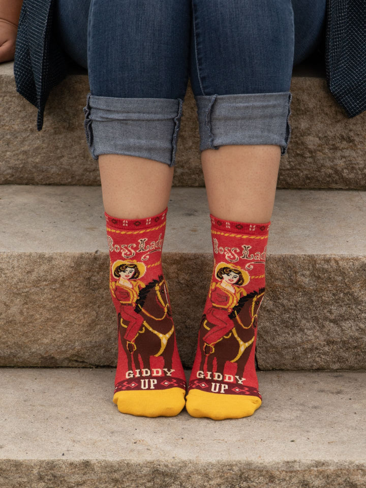 Person wearing red socks with horse and rider design on steps