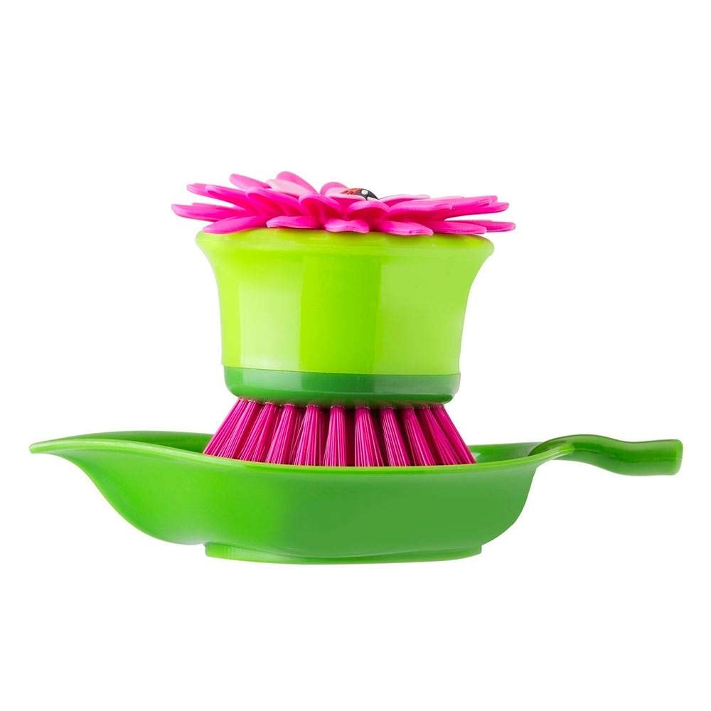 Green dish brush with pink bristles on a white background