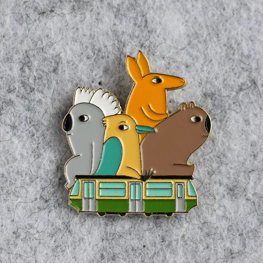Colorful Australian animals on a Melbourne tram -shaped pins on a textured gray background.