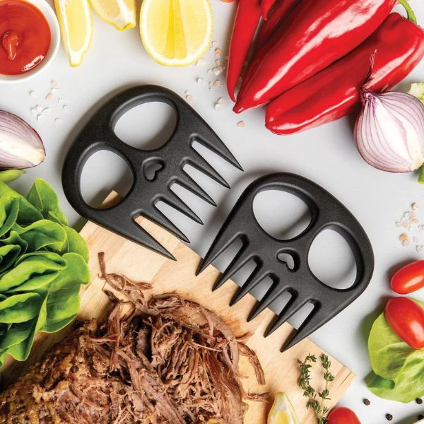 A flat lay picture of various food stuffs and a set of meat muncher black shredders