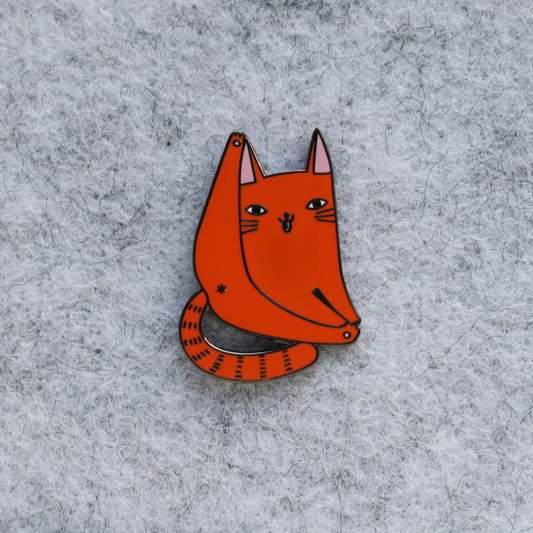 Orange cat-shaped pin on a gray textured background