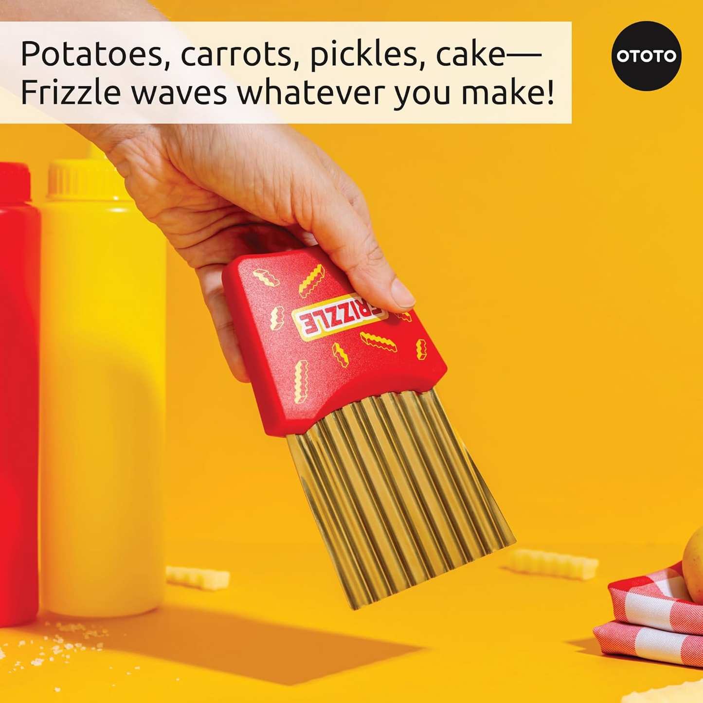 A hand extending the Frizzle crinkle fry cutter with a yellow background and sauce bottles.