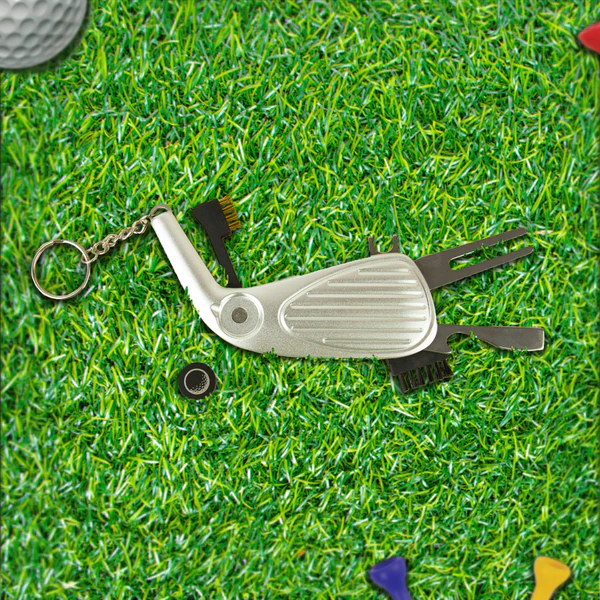 Golf club-shaped keychain tool on grass with golf ball and club in background