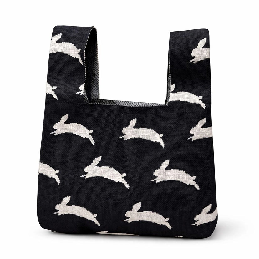 A black bag with leaping white rabbits on a white background.