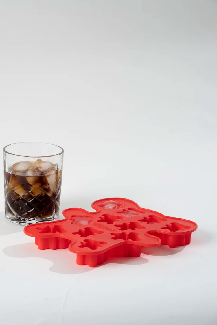 Red koala-shaped ice cube tray next to a glass of coke on a white background