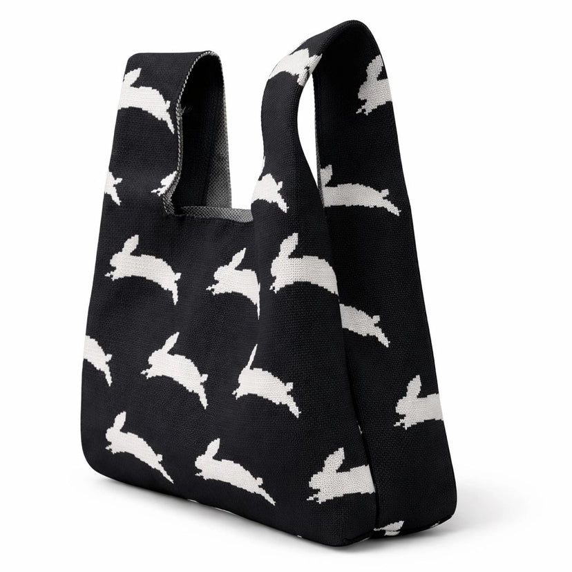 A black bag featuring white rabbits on a white background.