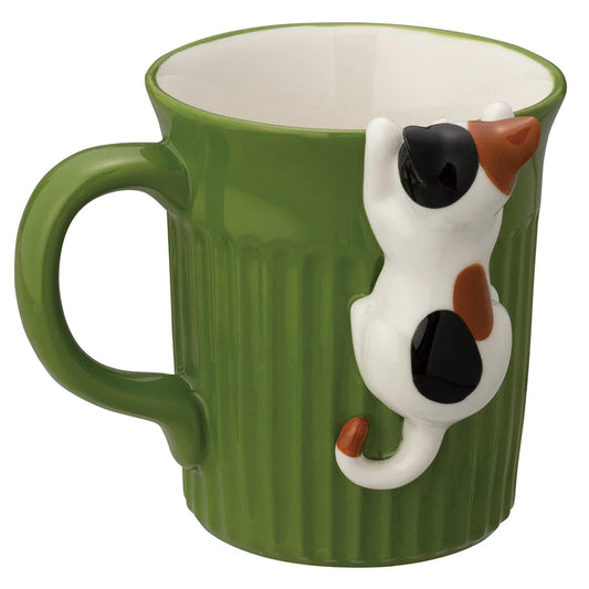 Green mug with a 3D calico cat design on a white background
