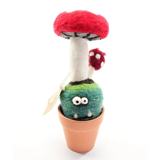A crazy looking wool felt mushroom in a po. The background is white.