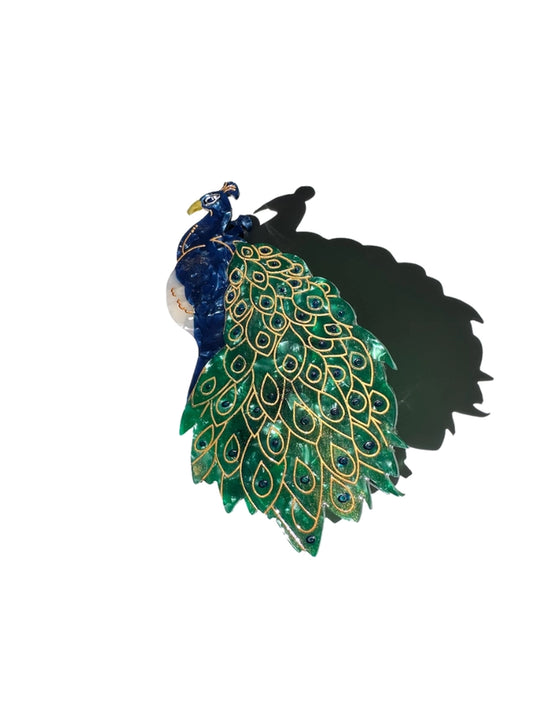 Peacock  hair clip with vibrant green and gold feathers on a white background