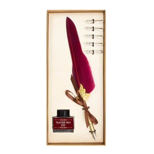A red feather quill, ink and five nibs in a gold gift box. The background is white.