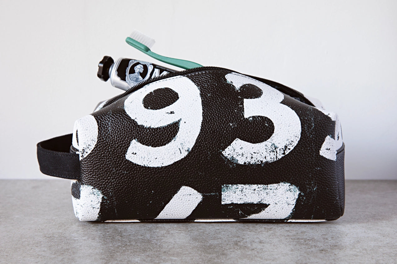 Black pouch with white numbers on a gray surface