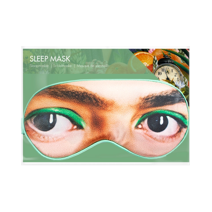 A green packaged eye mask of  the image closeup Frida Kahlo's eyes an eyebrows. The text reads: leep Mask. The background is white.