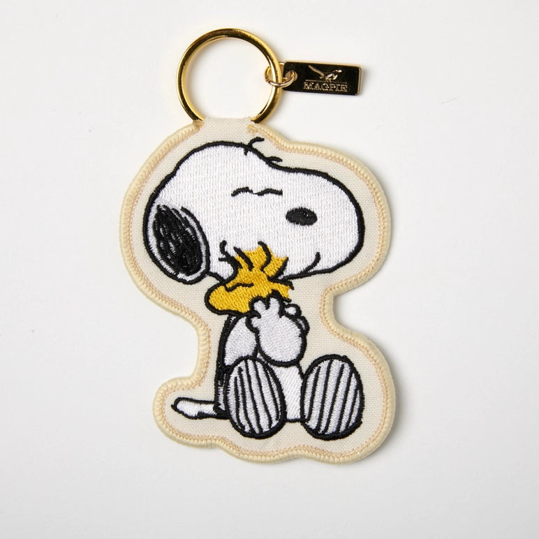 Keychain with a cartoon character holding a yellow flower on a white background