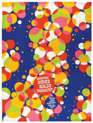An open blue BLUEQ Tea towel  with printed soap bubbles , text reads"Washing dishes builds character, maybe you should give it a try" |Gizmo Gifts