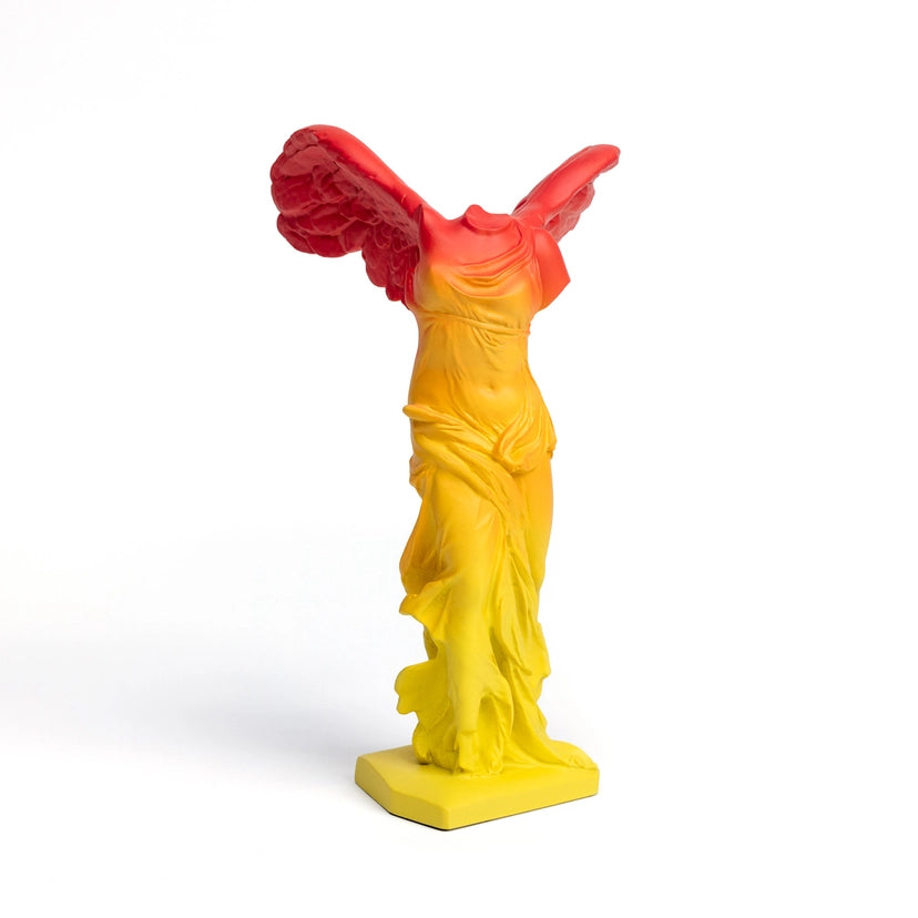 Winged Statue featuring red wings with yellow boy on a white background