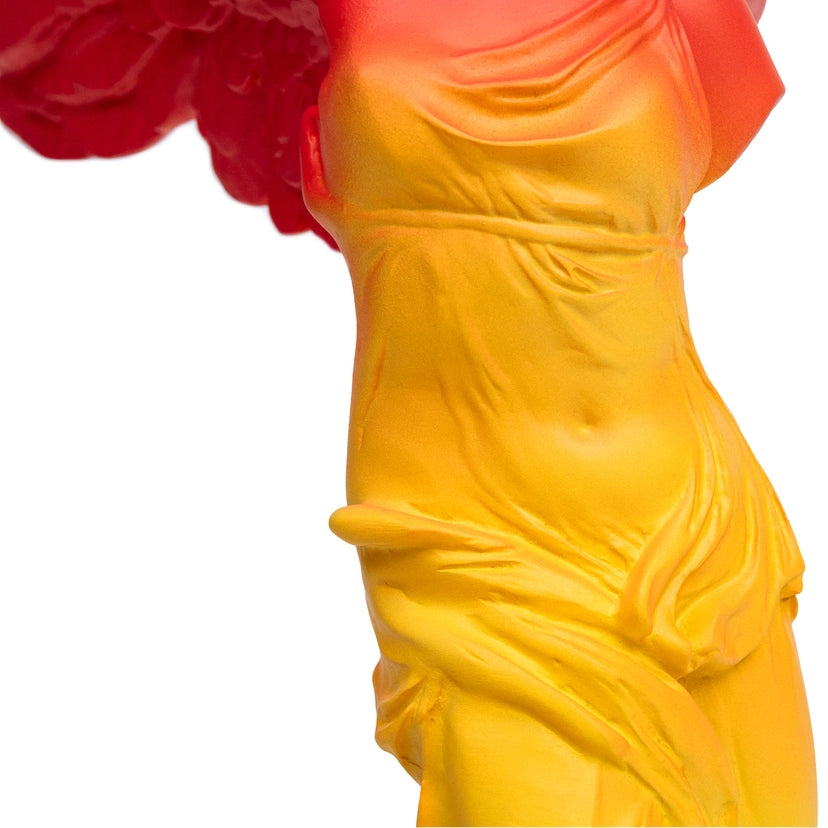 The close up detail of a yellow body of the winged victory statue on a white background.