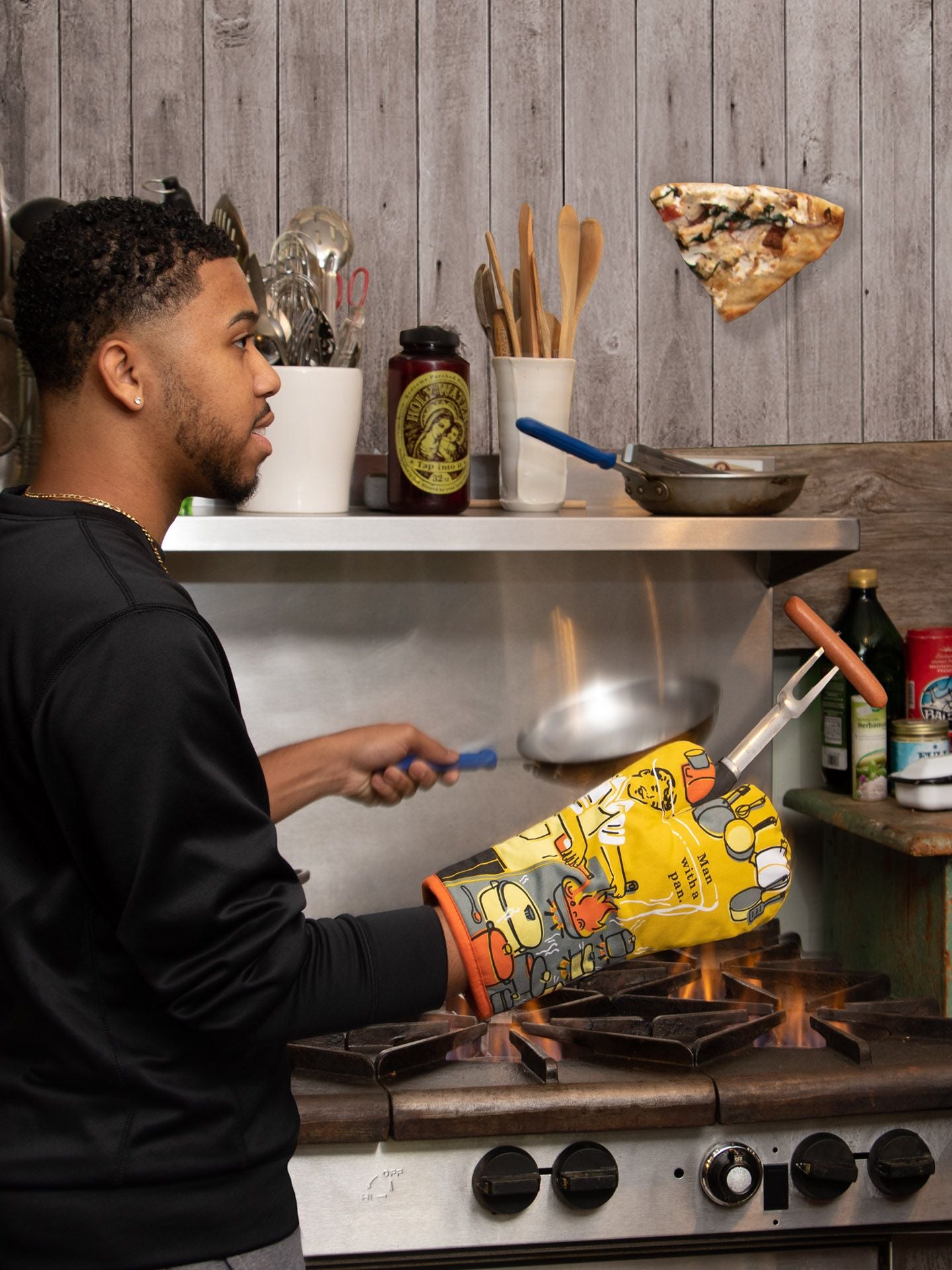 A lifestyBLUEQ-Oven mitt-Man with a pane photograph of a man cooking over a gas flame whilst wearing his oven mitt.